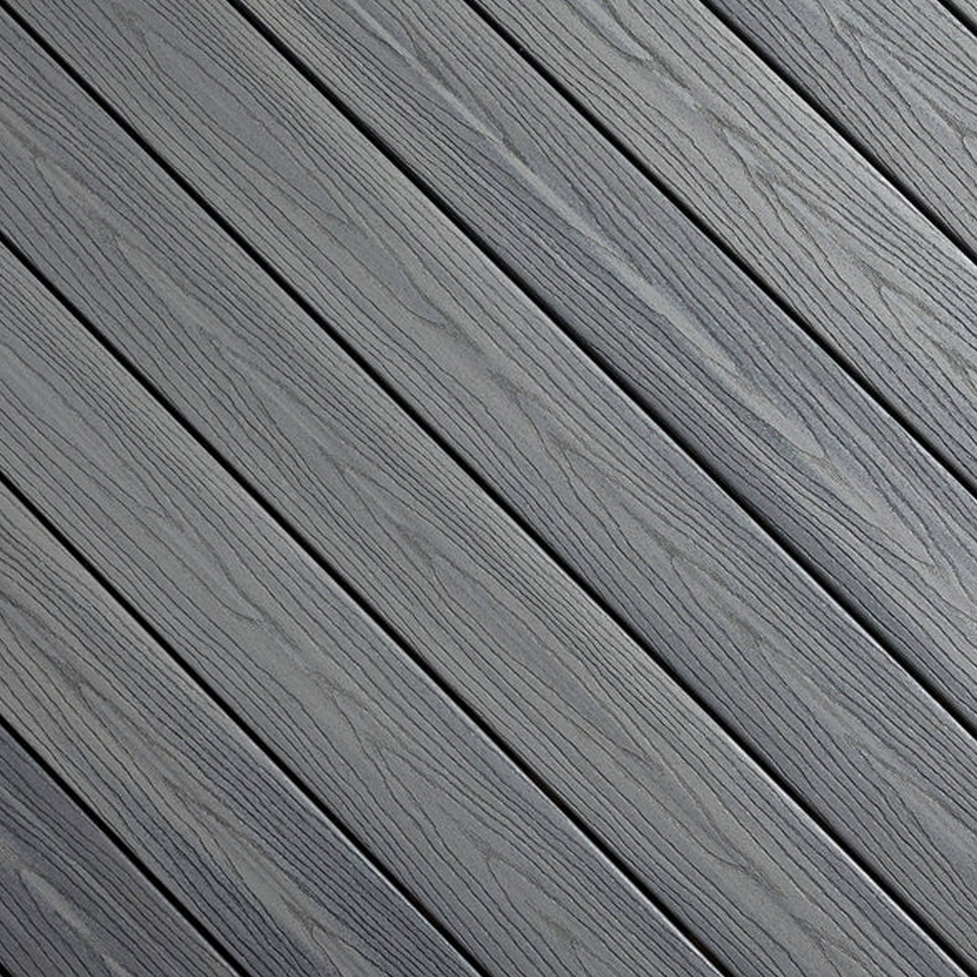 Close-up of Fiberon GoodLife Beach House composite decking board, showcasing its multi-tonal sandy brown grain and durable three-sided cap layer.