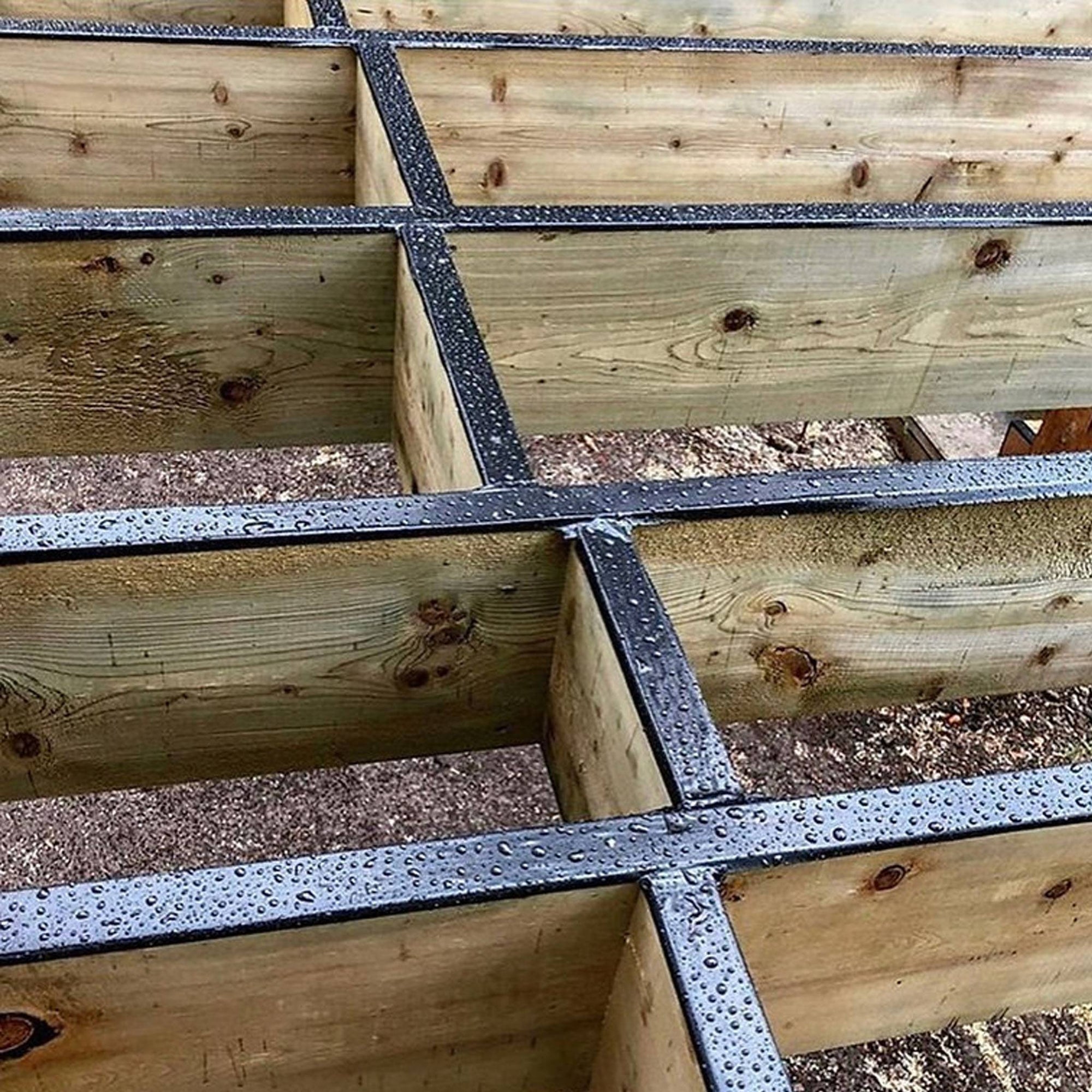 Waterproof GTape black flashing tape installed on deck joists and wooden framing.