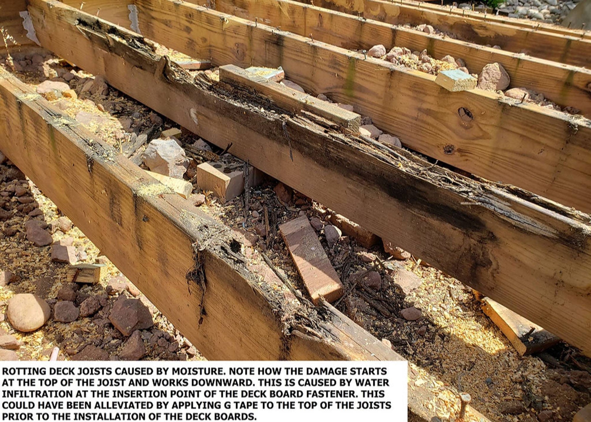 Rotting deck joists damaged by moisture due to lack of flashing tape protection.
