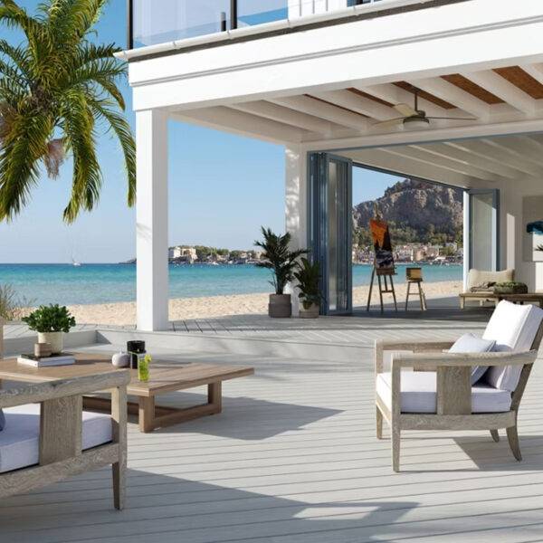 Luxury outdoor deck featuring Trex Lineage Salt Flat composite decking with a coastal-inspired light grey finish. The serene beachside setting showcases the decking’s modern design, paired with natural wood furniture and lush greenery. Perfect for high-end outdoor living with durability, fade resistance, and heat-mitigating technology.