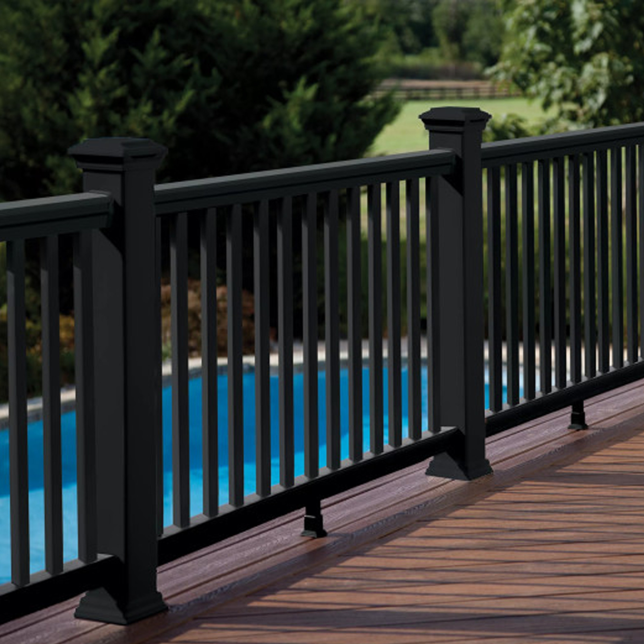 TREX Transcend composite railing in black with black square balusters, installed around a poolside deck